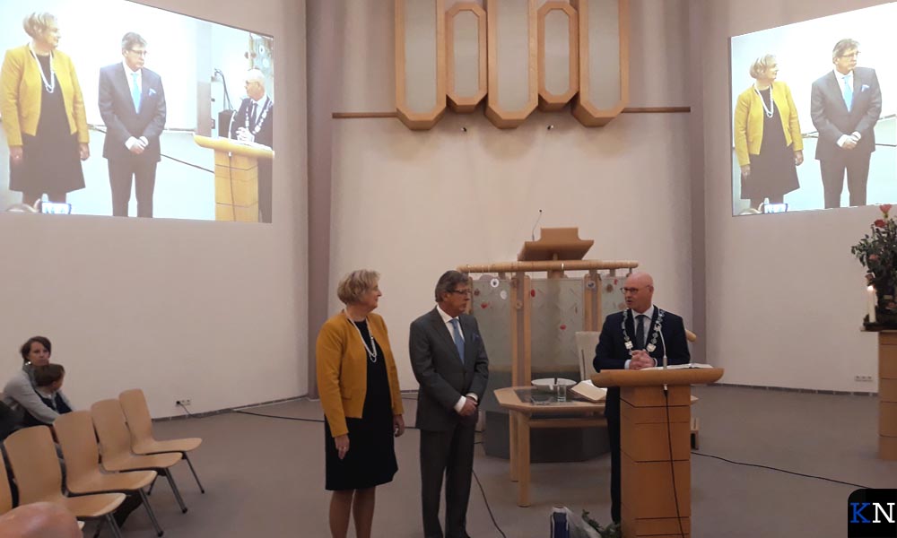 Burgemeester Koelewijn spreekt jubilerend organist Bleijenburg toe.