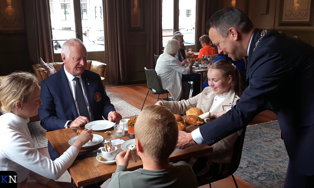 Burgemeester Sander de Rouwe en veteraan Steffen Hofstra lunchen met leerlingen tijdens een vrijheidsmaaltijd.