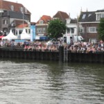 Vanaf de IJsselkade kijkt het publiek toe.