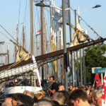 Uitzicht over het volle Van Heutszplein en een volle rivier.