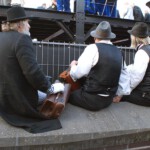 Drie straatmuzikanten stellen zich bescheiden achter de schermen op.